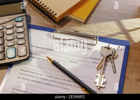 Blank real estate lease agreement, keys and calculator on office desk Stock Photo