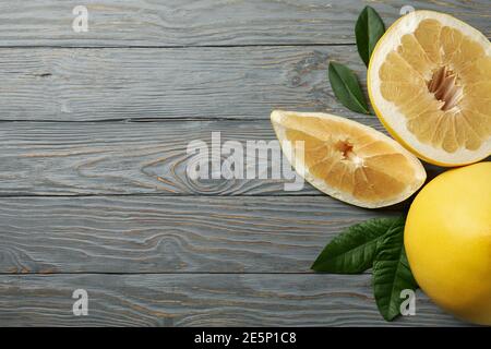 Ripe pomelo fruit and leaves on wooden background Stock Photo
