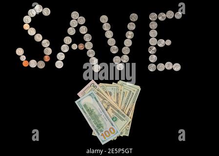 Coins isolated on solid black background spelling the word Save from loose coin change. Stock Photo