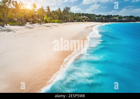 Aerial view of white sandy beach, ocean with waves at sunset Stock Photo