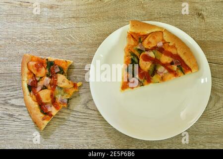 piece of Hawaiian pizza topping sausage and cheese on plate Stock Photo