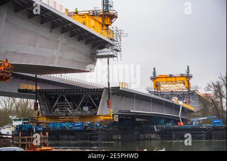 Mainz, Germany. 28th Jan, 2021. The last section is on a pontoon boat and is located between the other bridge sections. The last large section is currently being fitted into the new Schierstein bridge. The 2,000-tonne, 120-metre-long component is to be hoisted into its final position from a pontoon ship using steel cables. Credit: Andreas Arnold/dpa/Alamy Live News Stock Photo