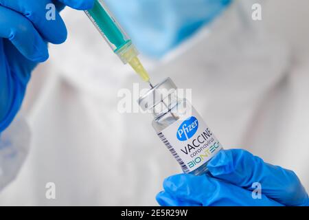 Pfizer and Biontech coronavirus Vaccine and syringe in the bottle or vial for injection in doctors hands. Covid-19, SARS-Cov-2 prevention, January Stock Photo