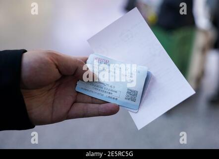 (210128) -- SHANGHAI, Jan. 28, 2021 (Xinhua) -- Gao Li shows his ticket at Shanghai Hongqiao Railway Station in Shanghai, east China, Jan. 28, 2021. On the first day of the Spring Festival travel rush in 2021, Gao Li, a 'post-90s' migrant worker in Shanghai, packed up his luggage and set foot on his way back to his hometown of Huangpi, Wuhan of central China for the Spring Festival. Before checking in, he fumbled for the negative nucleic acid testing report in his bag. Nothing could be more important than this piece of 'luggage'. Two days ago, Shanghai medical workers came to Gao Li's wor Stock Photo