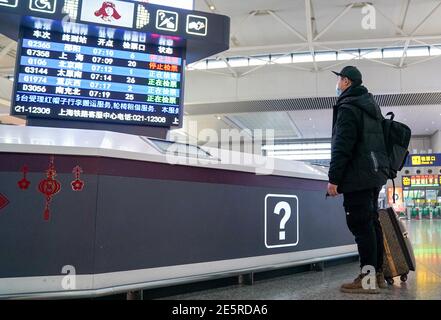 (210128) -- SHANGHAI, Jan. 28, 2021 (Xinhua) -- Gao Li checks the train information at the departure hall of Shanghai Hongqiao Railway Station in Shanghai, east China, Jan. 28, 2021. On the first day of the Spring Festival travel rush in 2021, Gao Li, a 'post-90s' migrant worker in Shanghai, packed up his luggage and set foot on his way back to his hometown of Huangpi, Wuhan of central China for the Spring Festival. Before checking in, he fumbled for the negative nucleic acid testing report in his bag. Nothing could be more important than this piece of 'luggage'. Two days ago, Shanghai me Stock Photo