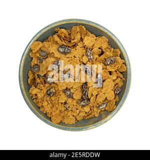 Top view of a bowl filled with bran flakes and raisins breakfast cereal isolated on a white background. Stock Photo