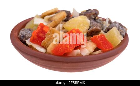 Side view of a small bowl filled with several varieties of dried fruit isolated on a white background. Stock Photo