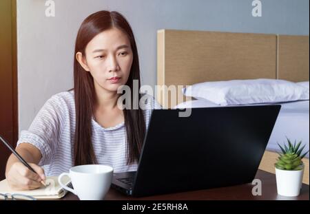 new normal, work from home, study online, homeschooling, distance education. Asia student woman study online, listen lecture via laptop at home Stock Photo