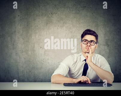 Portrait of a business man sitting at desk thinking daydreaming Stock Photo