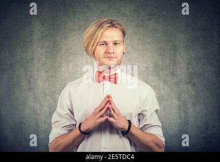 Sneaky scheming young man looking at camera Stock Photo