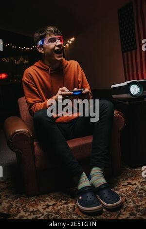 Young man in glowing glasses playing video game Stock Photo