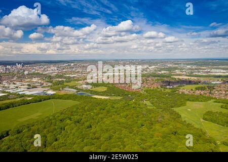Aerial photo of the city of Leeds viewed from the village of Middleton and Middleton Park on a sunny day with white clouds in the sky and a lot of gre Stock Photo