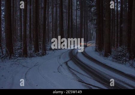 Country road in winter after a heavy snowfall leading through a small village in Upper Bavaria Stock Photo