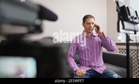 Man calling by phone from video studio. Stock Photo