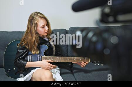 Teenage girl with semi-acoustic guitar in front of the video camera. Stock Photo