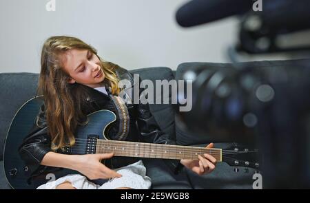 Teenage girl with semi-acoustic guitar in front of the video camera. Stock Photo