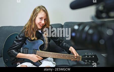 Teenage girl with semi-acoustic guitar in front of the video camera. Stock Photo