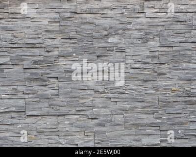 Wall with decorative gray embossed narrow tile cladding Stock Photo