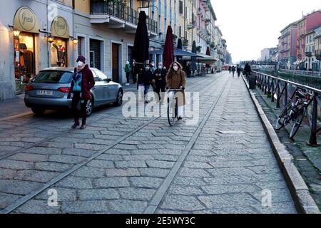 Milan, People stroll at sunset and full moon on the Naviglio Grande Editorial Usage Only Stock Photo