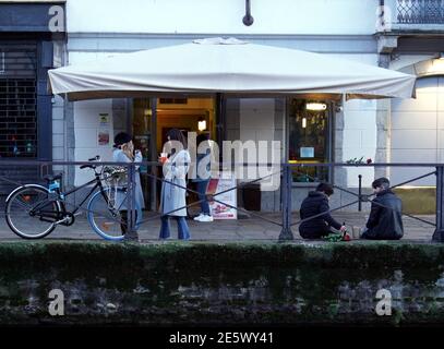 Milan, People stroll at sunset and full moon on the Naviglio Grande Editorial Usage Only Stock Photo