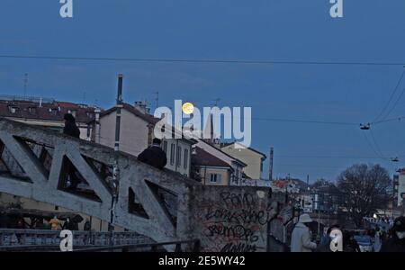 Milan, People stroll at sunset and full moon on the Naviglio Grande Editorial Usage Only Stock Photo