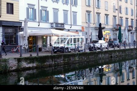 Milan, People stroll at sunset and full moon on the Naviglio Grande Editorial Usage Only Stock Photo