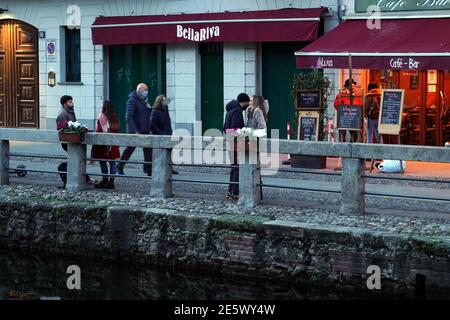 Milan, People stroll at sunset and full moon on the Naviglio Grande Editorial Usage Only Stock Photo