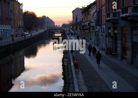 Milan, People stroll at sunset and full moon on the Naviglio Grande Editorial Usage Only Stock Photo