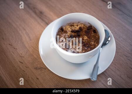 A bowl of oat porridge and raisins. Stock Photo