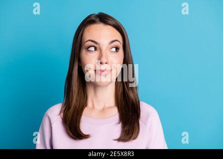 Photo of lovely charming young lady interested look side empty space smiling wonder how much cost dress if she use promo coupon wear violet pullover Stock Photo