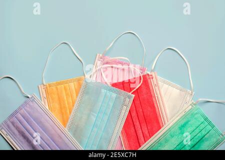 Colored protective surgical masks on blue background.Covid 19 concept Stock Photo