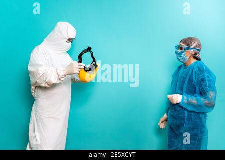 Stock photo of unrecognized person talking with healthcare worker wearing protective suit for covid19. Stock Photo