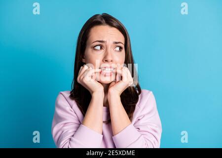 Closeup headshot photo of pretty horrified young lady anxious look empty space biting nails husband come home drunk abusing child wear violet pullover Stock Photo