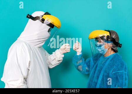 Stock photo of unrecognized person talking with healthcare worker wearing protective suit for covid19. Stock Photo