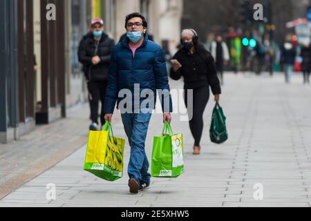 London UK. 28 January 2021. A man walking with full Asda shopping