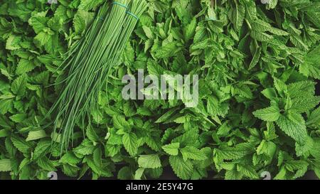 Fresh mint leaves and bunch of chives on display at herbs market Stock Photo