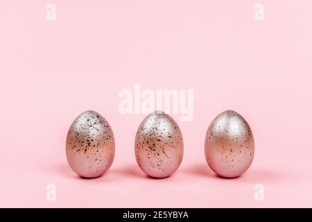 Easter eggs of silver colors with black dots on a pink background Stock Photo