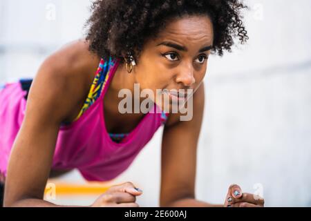 Afro athlete woman doing pushups outdoors. Stock Photo