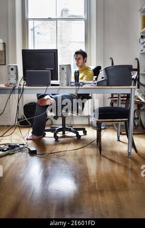 Young man working on computer in study room at home Stock Photo