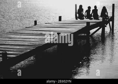 Black and white photo of happy family on pier Stock Photo