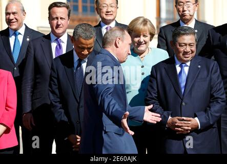 Russian President Vladimir Putin holds out his arms as he walks past U.S. President Barack Obama (centre L) during a group photo at the G20 Summit in St. Petersburg September 6, 2013. Above Obama is British Prime Minister David Cameron, above Putin is German Chancellor Angela Merkel. At right is Indonesian President Susilo Bambang Yudhoyono.   REUTERS/Kevin Lamarque  (RUSSIA - Tags: TPX IMAGES OF THE DAY BUSINESS POLITICS)