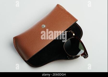 Sunglasses in case isolated. Brown case with dark lenses Stock Photo