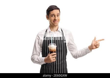 Barista holding coffee in a takeaway plastic cup and pointing to the side isolated on white background Stock Photo
