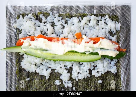 Woman using bamboo rolling mat for home made sushi Stock Photo - Alamy