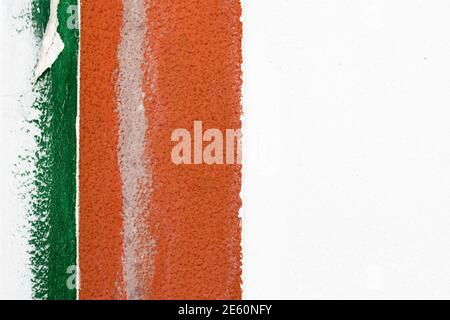 Detail of an old white cement wall with border of two painted vertical strips in green and orange color on the left side of frame. Abstract design Stock Photo