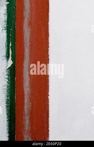 Detail of an old white cement wall with border of two scratched vertical strips in green and red paint on the left side of frame. Abstract design Stock Photo