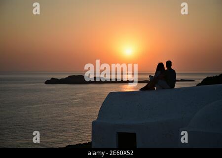 Sunset seascape with panoramic view of Aghios Nikolaos Krassas, a Greek Orthodox chapel and people silhouettes in Kythira island, Attica Greece. Stock Photo