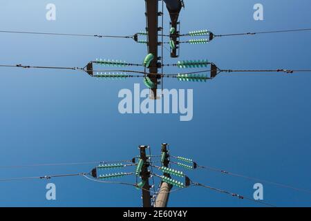 High voltage power lines on deep blue sky, bottom view Stock Photo