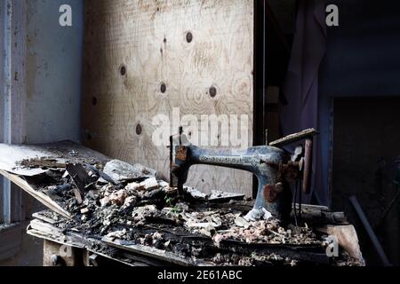 A rusty vintage Singer sewing machine left to rot inside an abandoned house. Ontario, Canada. Stock Photo