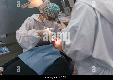 Dentist woman doctor injecting anesthesia to young man before dental teeth treatment - People body care concept for healthy lifestyle. Stock Photo